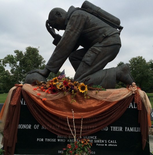 The centerpiece of the display is a large bronze figure of a kneeling firefighter, sculpted by S. Mariami in 2001 and dedicated in 2003. 