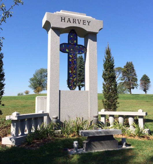 Jack Harvey's monument, featuring a stained glass cross, is a colorful addition to the landscape.